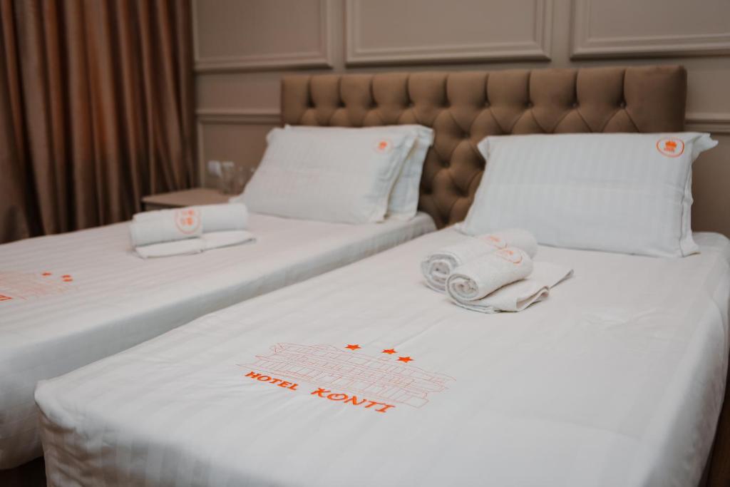 戈里察Hotel Konti的酒店房间里的两张床上有毛巾
