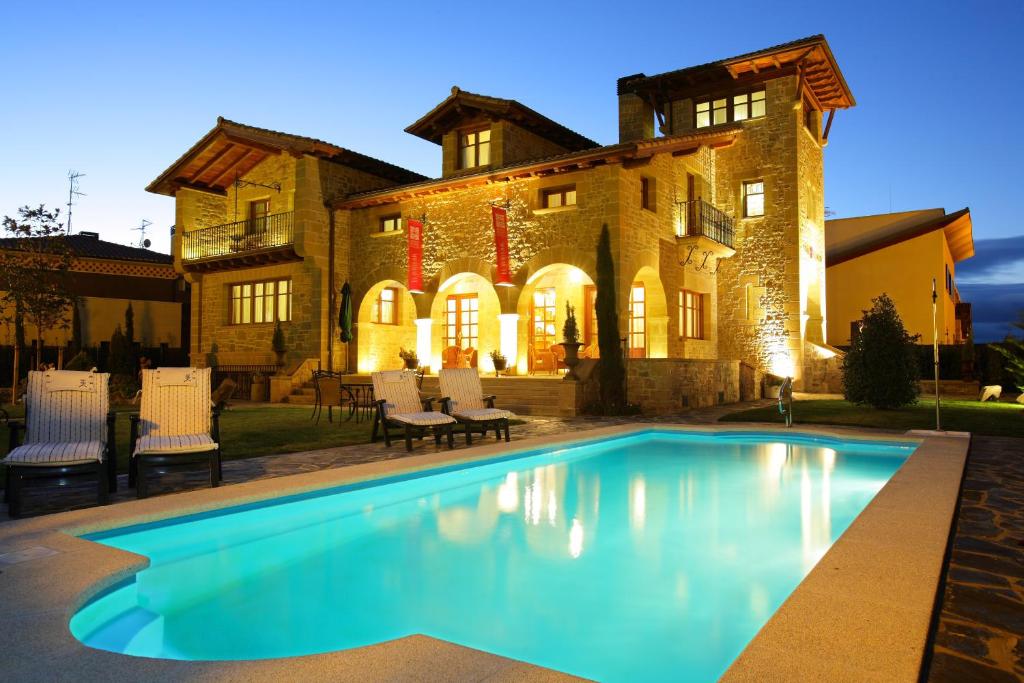 a house with a swimming pool in front of a house at Hotel El Juglar in Olite