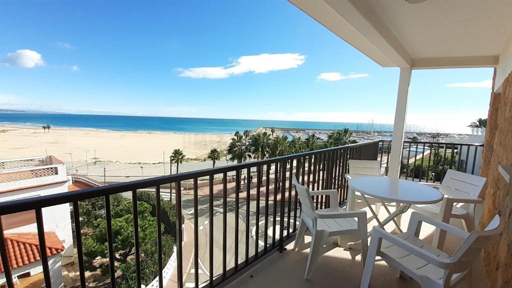 einen Balkon mit Tisch und Stühlen sowie Strand in der Unterkunft Apartamentos Dins Mar Apto. 11 in Torredembarra
