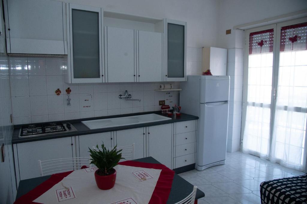 una cocina con armarios blancos y una mesa con una planta en 'Panta rei', en Mentana