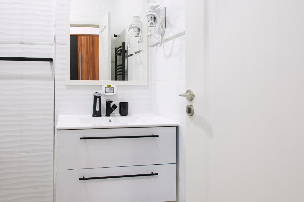 a white bathroom with a sink and a mirror at Complex Pescăresc Gura Repezii Borșa in Borşa