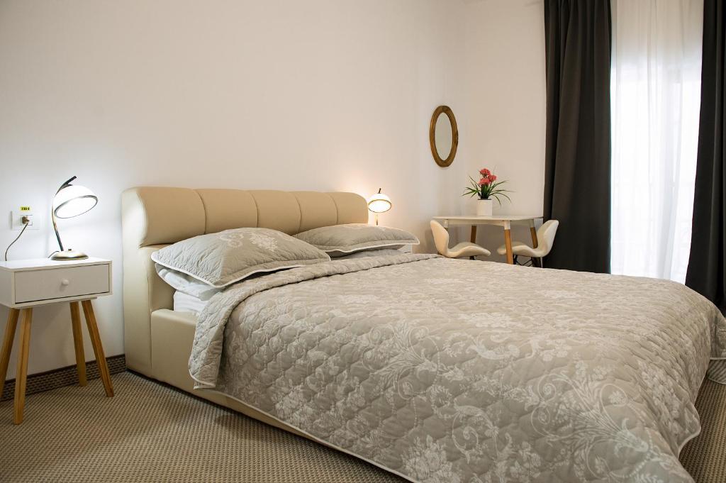 a bedroom with a large bed and a table at Complex Pescăresc Gura Repezii Borșa in Borşa