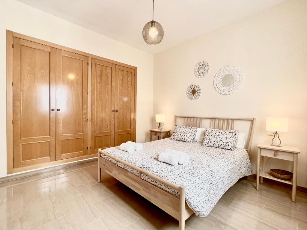 sypialnia z łóżkiem i dwoma ręcznikami na nim w obiekcie Teodosio Apartment FREE PARKING & CENTRAL AC w Sewilli