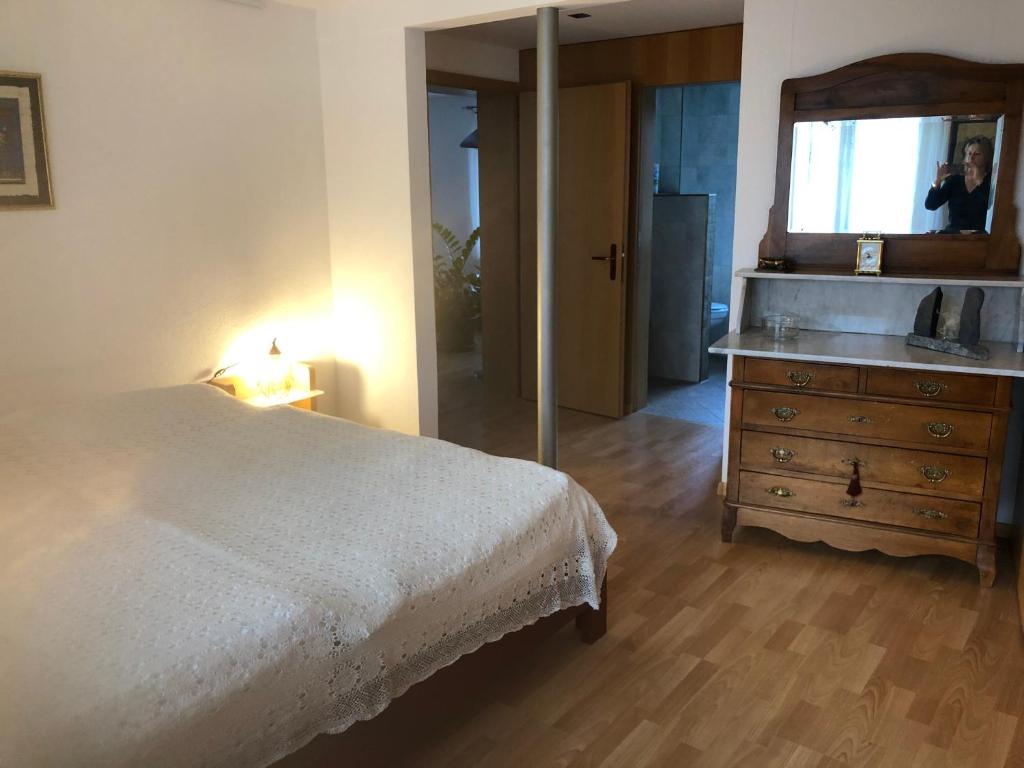 a bedroom with a bed and a mirror and a dresser at Albergo Diffuso Porrentruy in Porrentruy