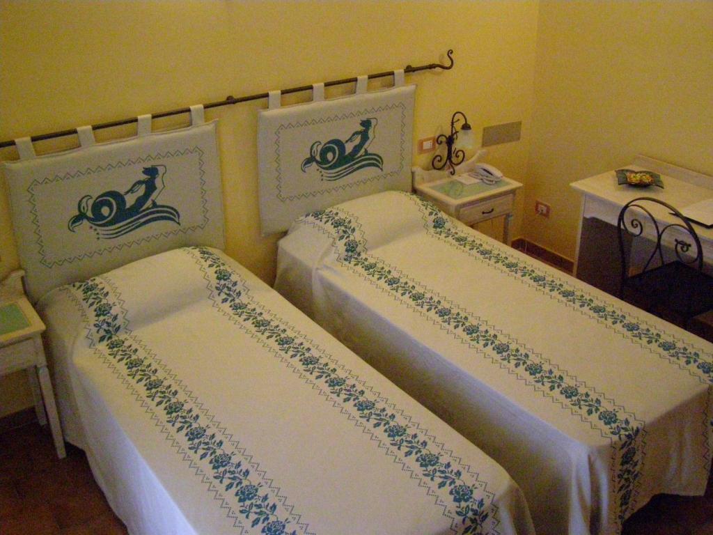 A bed or beds in a room at LE NEREIDI Hotel & Residence con Piscina-Tennis-Fitness-Parcheggio coperto-Sala Conferenze