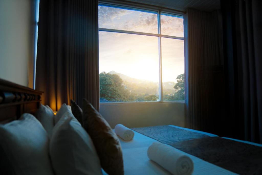 Un pat sau paturi într-o cameră la Kandy Tower Inn
