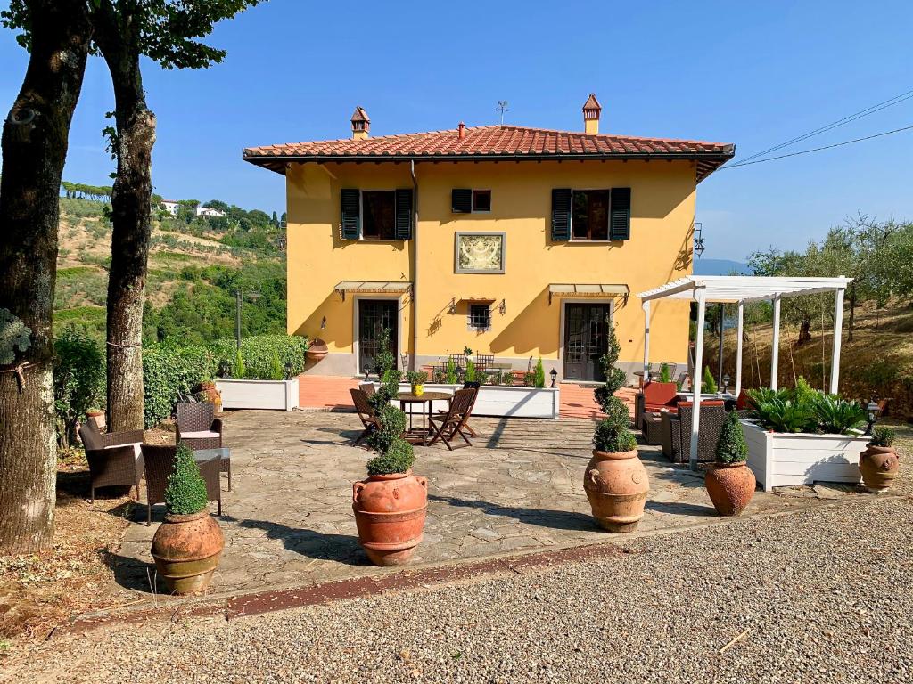 a yellow house with potted plants in front of it at Barco Mediceo B&B In Toscana in Carmignano