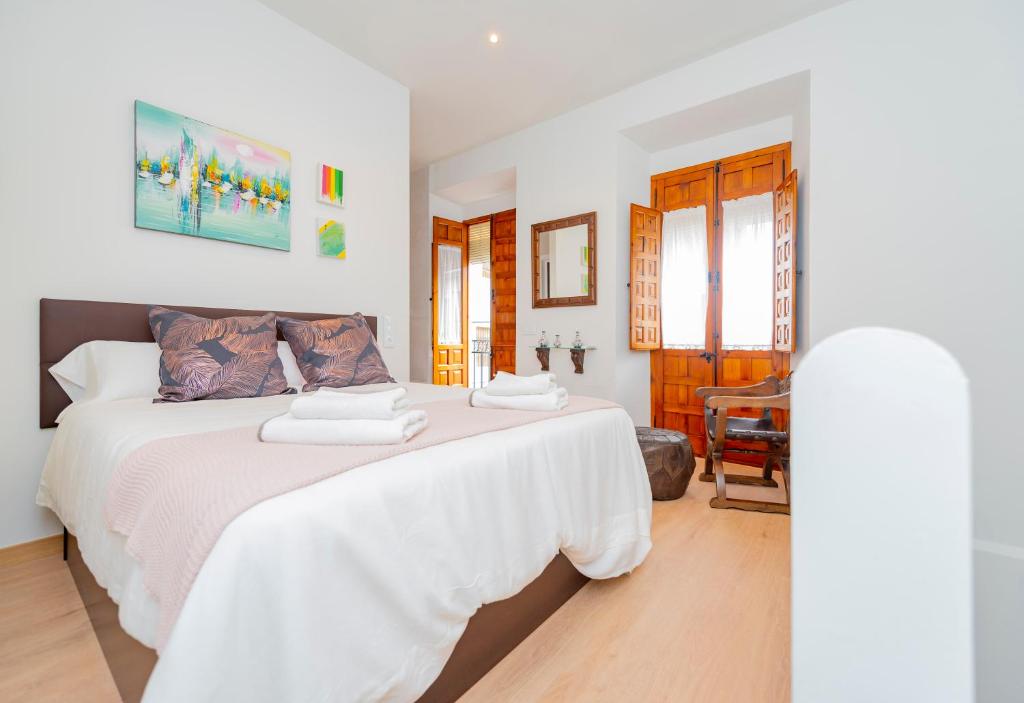 a bedroom with a white bed with two towels on it at CASA EL RINCONCITO in Antequera