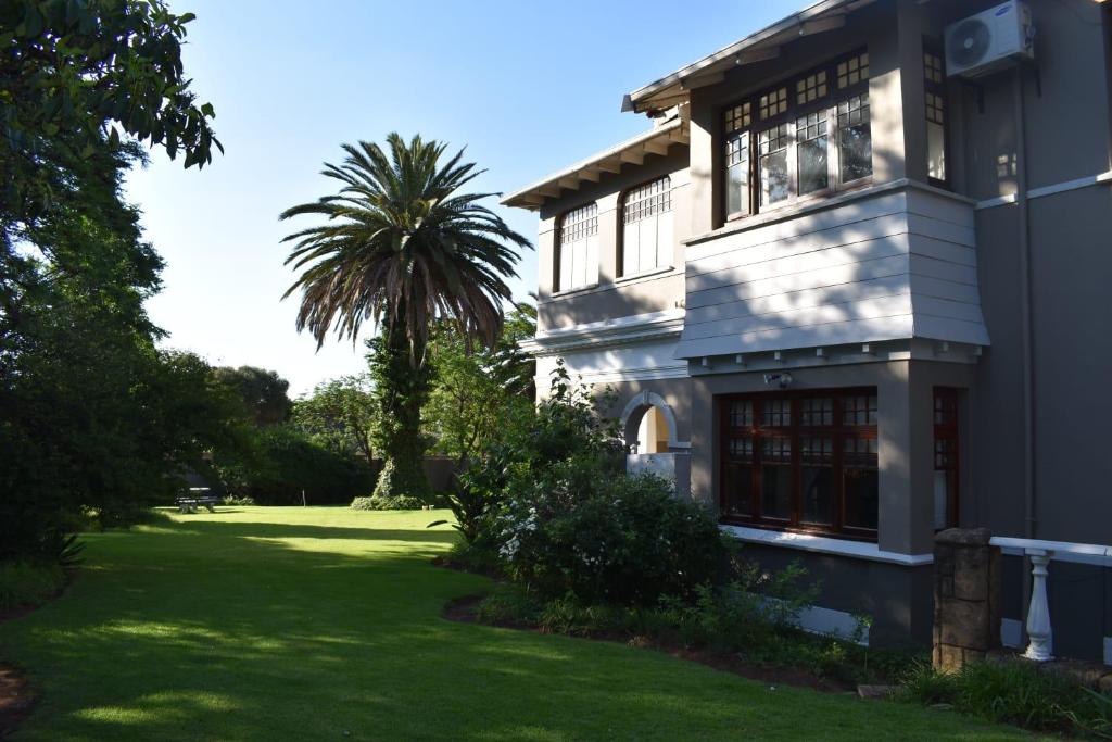 a house with a palm tree in the yard at Victorian Villa Westdene Benoni in Benoni