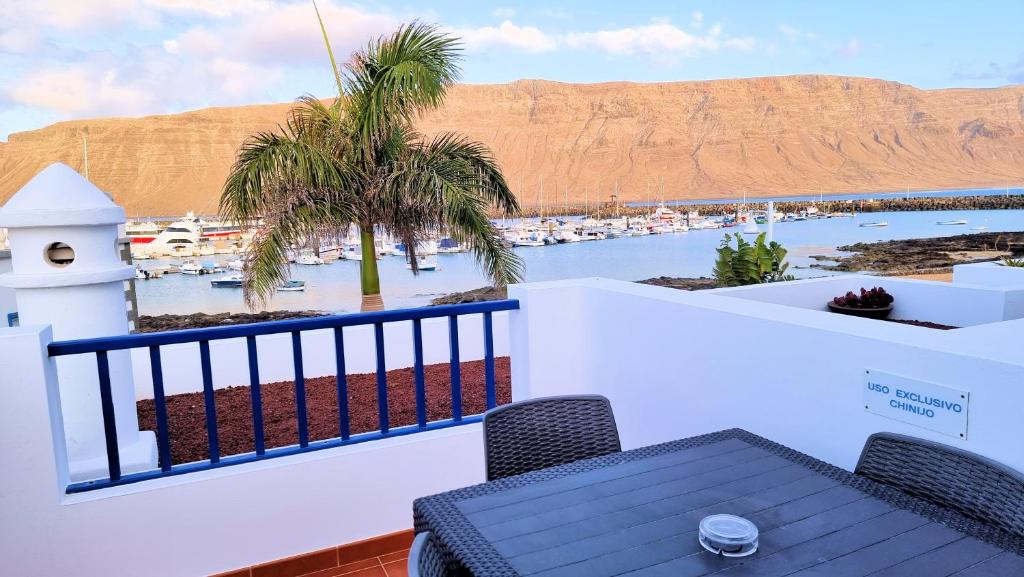 a balcony with a table and a view of a harbor at Chinijo Beach in Caleta de Sebo