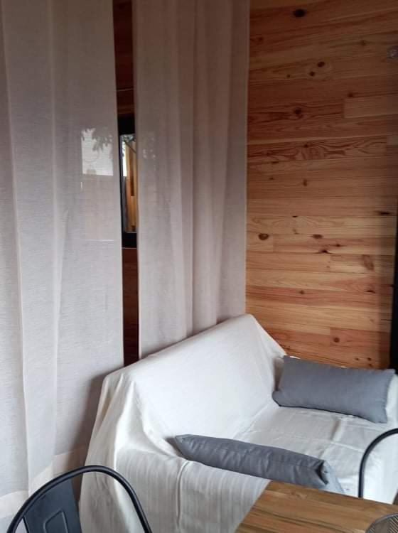 a bedroom with a white bed and a wooden wall at Bungalow de la caz l'écho in Cilaos