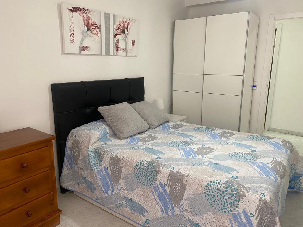 a bedroom with a bed and a dresser at Hermoso piso/apartamento amueblado patraix Valencia. in Valencia