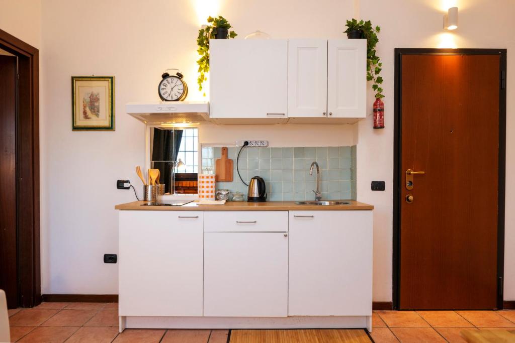uma cozinha com armários brancos e um lavatório em Residence San Raffaele 1 em Milão