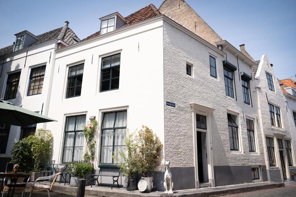 a white building with a dog sitting in front of it at De Soeten Inval in Middelburg