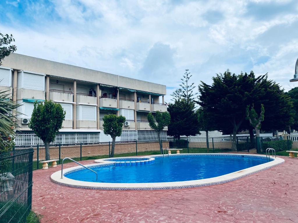 una piscina frente a un edificio en Apartamento Mil Palmeras, en Pilar de la Horadada