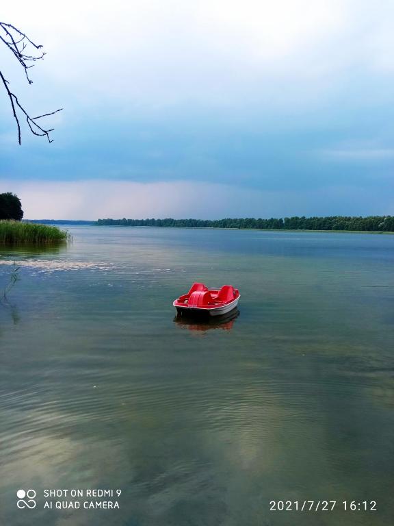 ein rotes Boot, das mitten auf einem See liegt in der Unterkunft Pokoje u Roberta in Angerburg