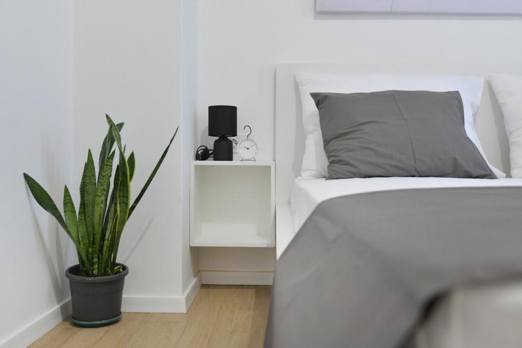 sypialnia z łóżkiem i doniczką w obiekcie Residence Family Plazina - Place 1 & 2 w Petrčane
