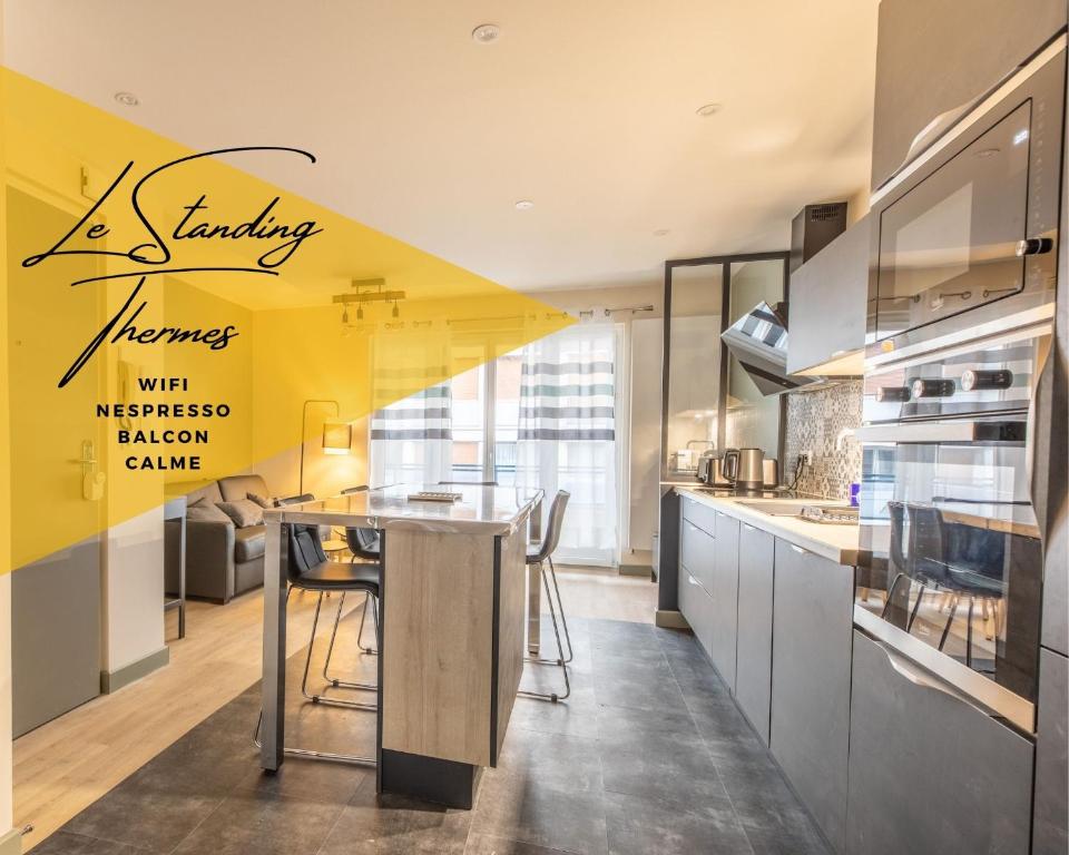 een keuken met een tafel en een gele muur bij STANDING THERMES Confort in Vichy