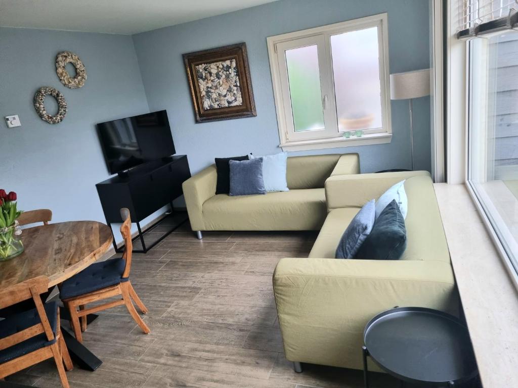 een woonkamer met een bank en een tafel bij Mooi zo 1 in De Koog