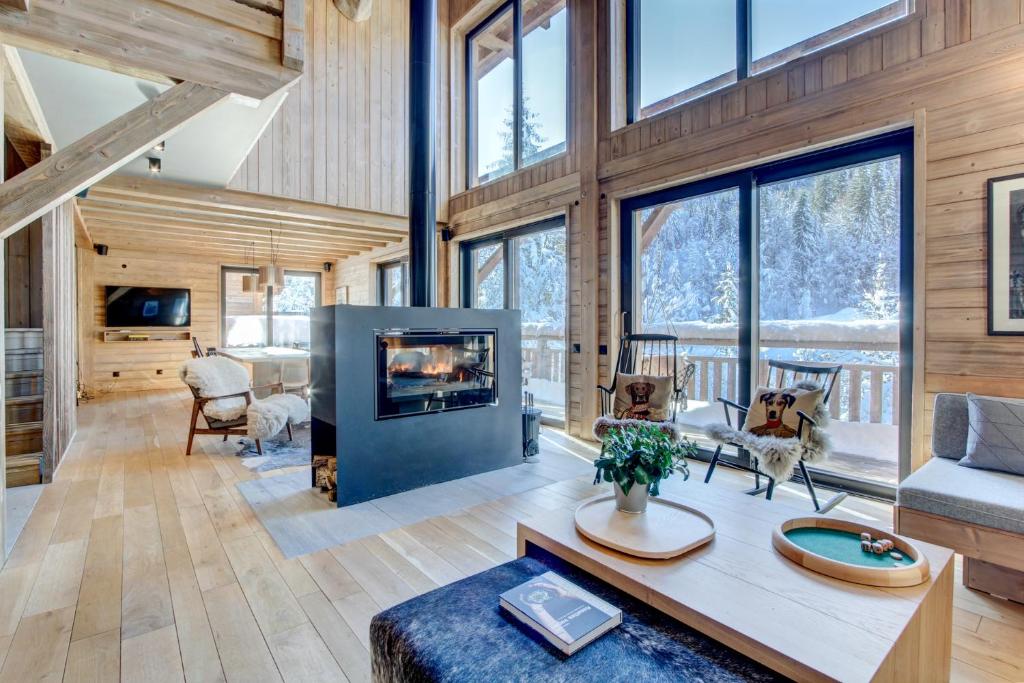 - un salon avec une cheminée dans une maison dans l'établissement Chalet La Mésange Azurée, à Morzine