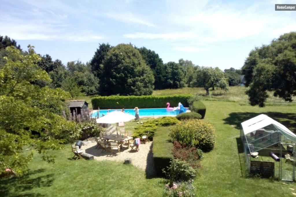 einen Garten mit Pool im Hintergrund in der Unterkunft Roulottes Les Alpaguettes in Saint-Romain-de-Benet