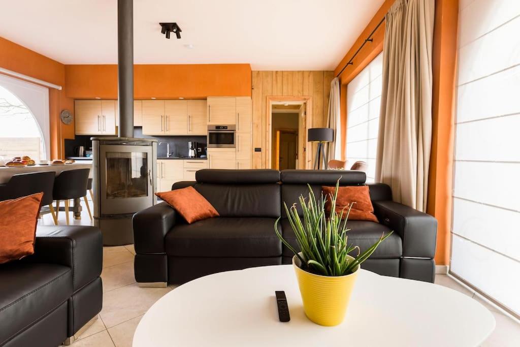 De Notelaar في Alveringem: غرفة معيشة مع أريكة سوداء وطاولة
