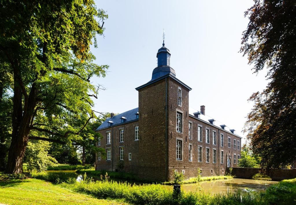 an old brick building with a tower on top of it at Kasteel Wolfrath in Born