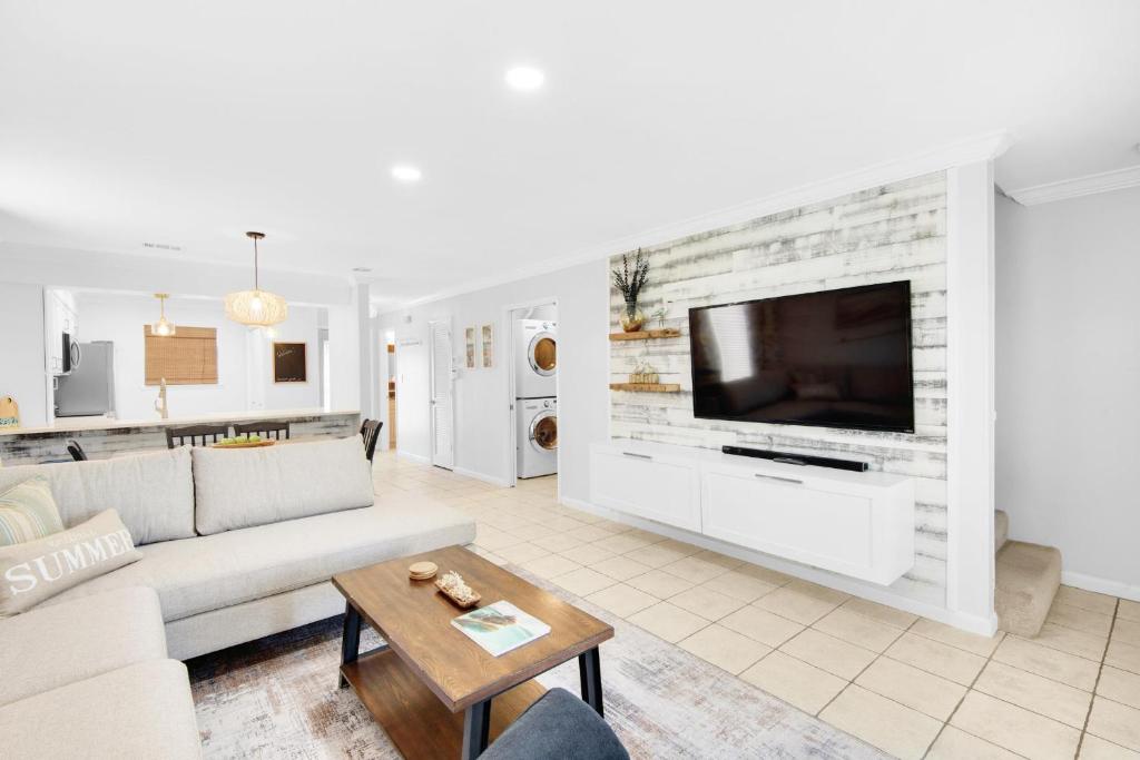 a living room with a couch and a tv at Summerhouse Townhomes #5 in Destin