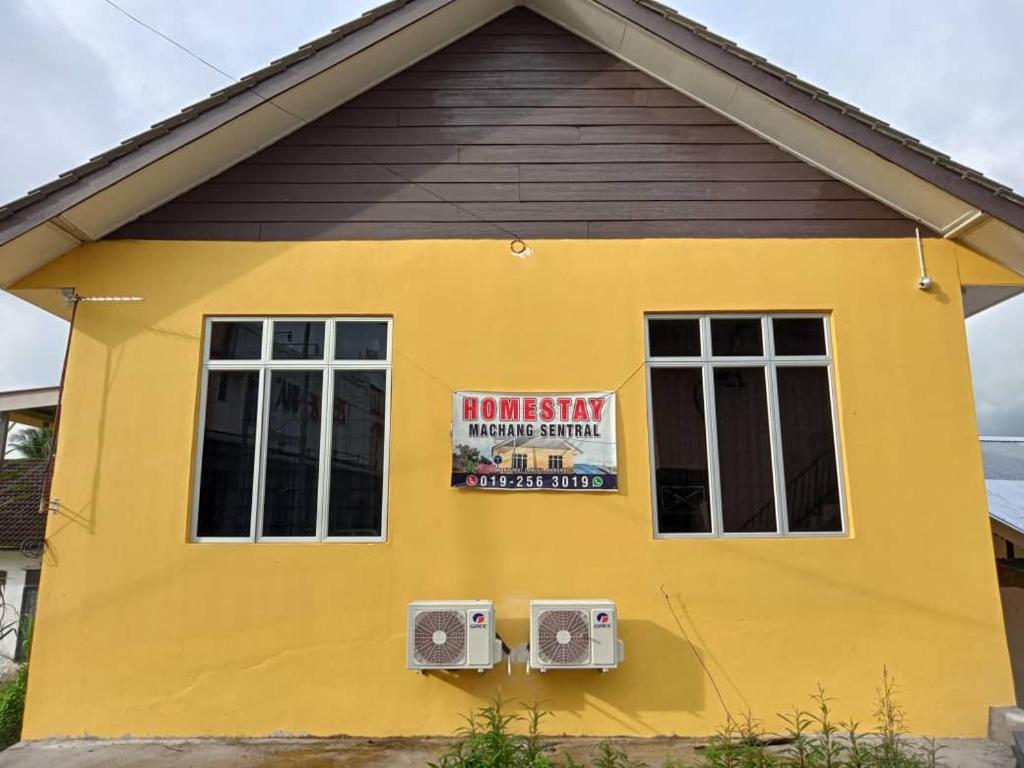 a yellow house with a sign on it at Homestay Machang Sentral in Machang