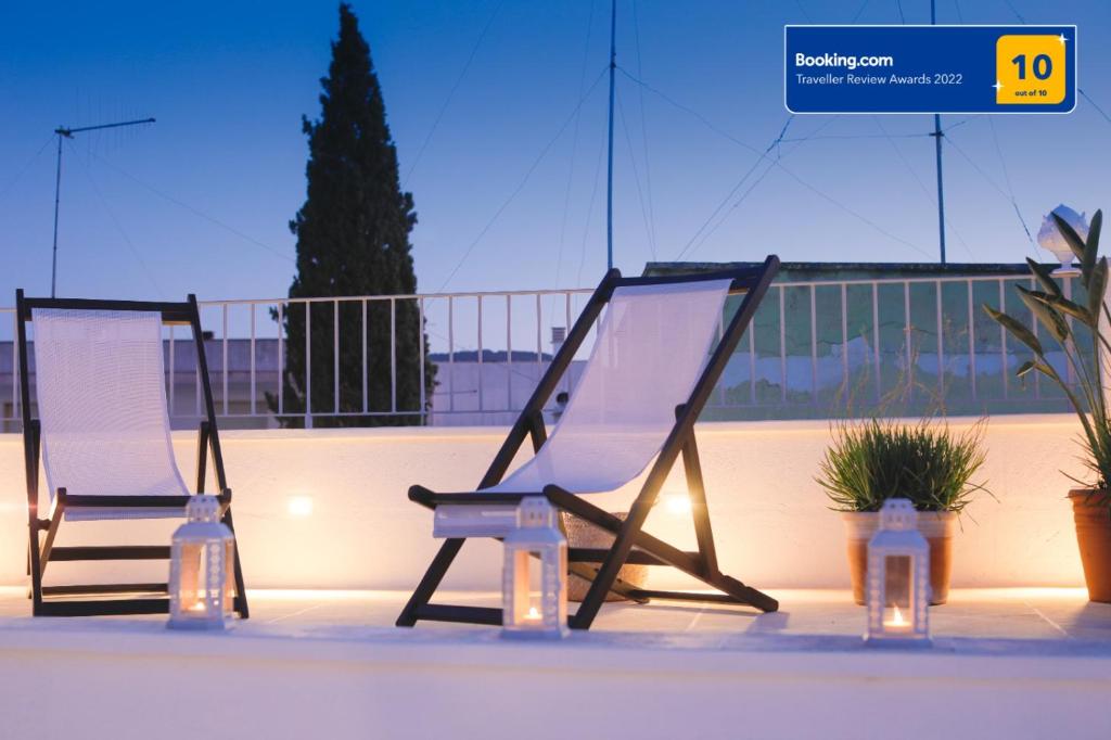 Duas cadeiras sentadas em cima de uma varanda com luzes em Dimora D'Erchia Apulian Holidays em Fasano