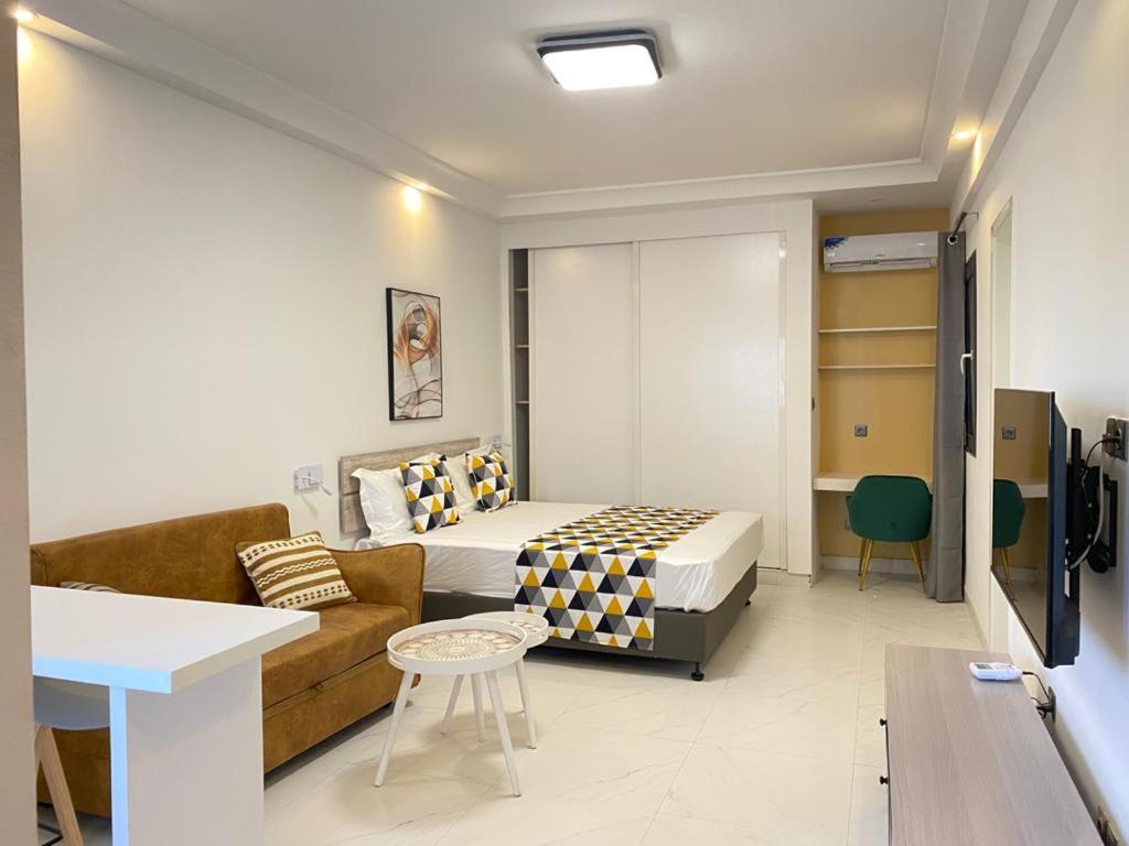 Habitación de hotel con cama y sofá en Résidence Cap Sud, en Dakar