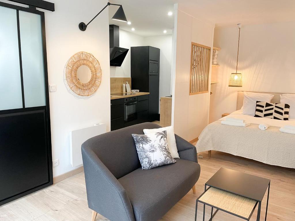 ein Wohnzimmer mit einer Couch und einem Bett in der Unterkunft COZYMAINE, superbe studio au coeur d'Angers in Angers