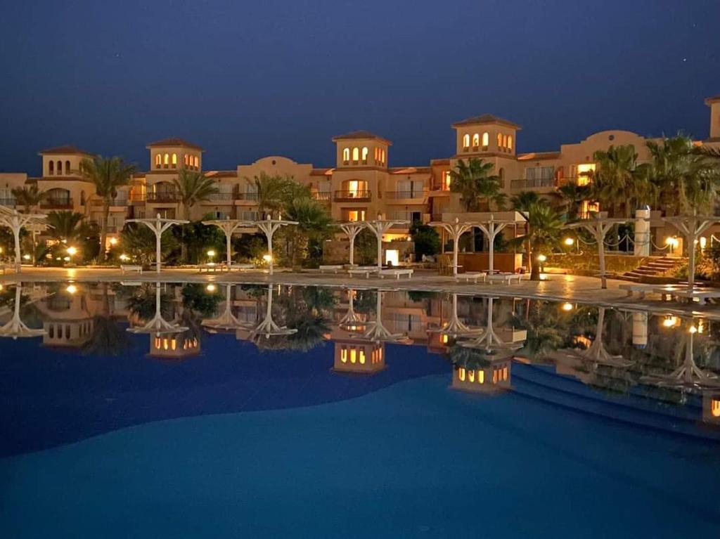 a view of a resort with a pool at night at Pensee Royal Garden Beach Resort in Quseir