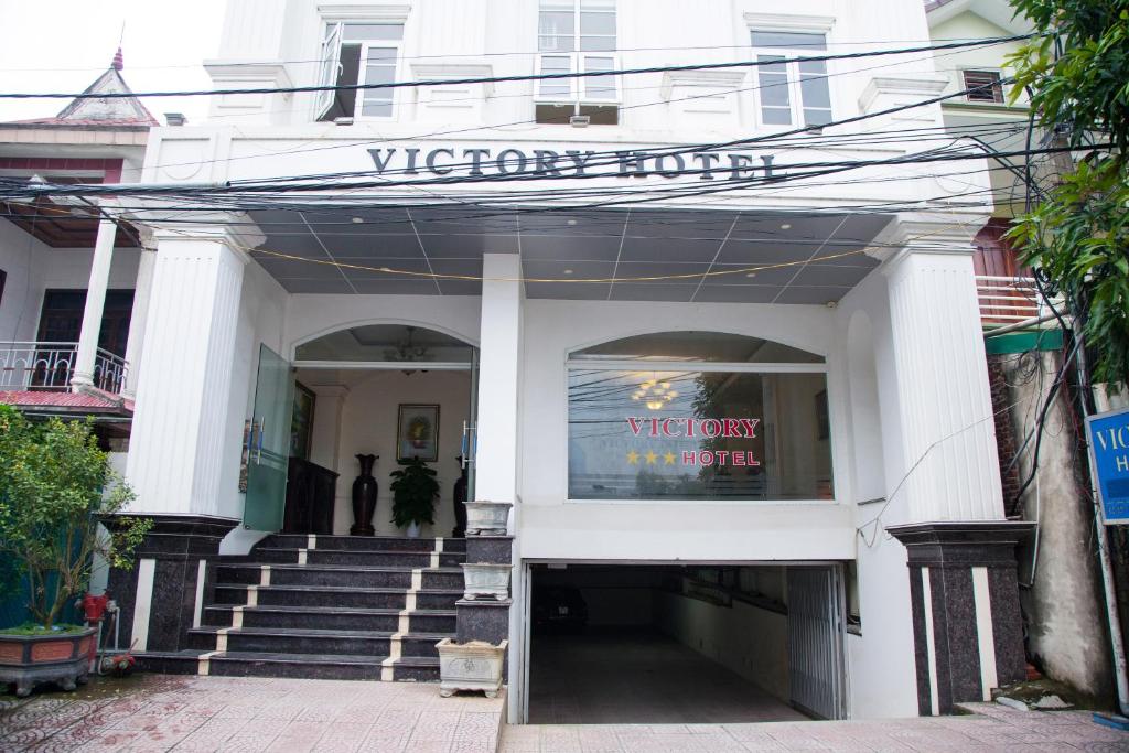 榮市的住宿－Victory Hotel, số 7, Vương Thúc Mậu, Tp Vinh，一座白色的建筑,上面有读取胜利宾馆的标志