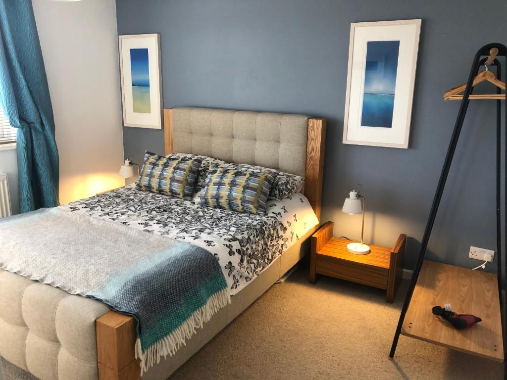 a bedroom with a bed and a table and two windows at Beach Road- short walk to Charlestown, Carlyon Bay & coastal paths in Carlyon Bay