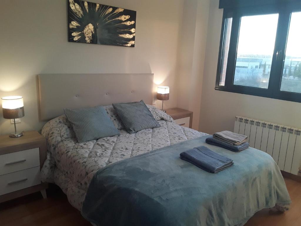 1 dormitorio con 1 cama con 2 toallas en Apartamento de 6 personas con WIFI Y GARAJE INCLUIDO en Valladolid