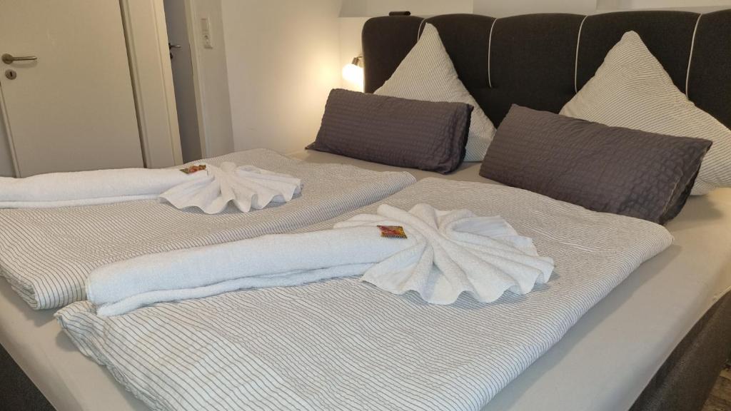 dos toallas blancas están sentadas en una cama en Pension Likedeeler Suite Majestät Sir Francis Drake, en Borkum