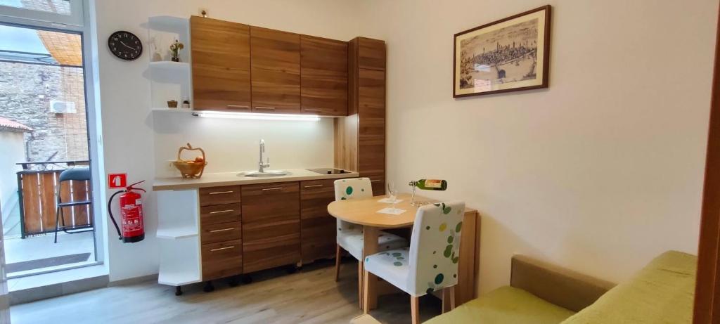 a small kitchen with a table and a sink at Apartma Gušt Koper in Koper