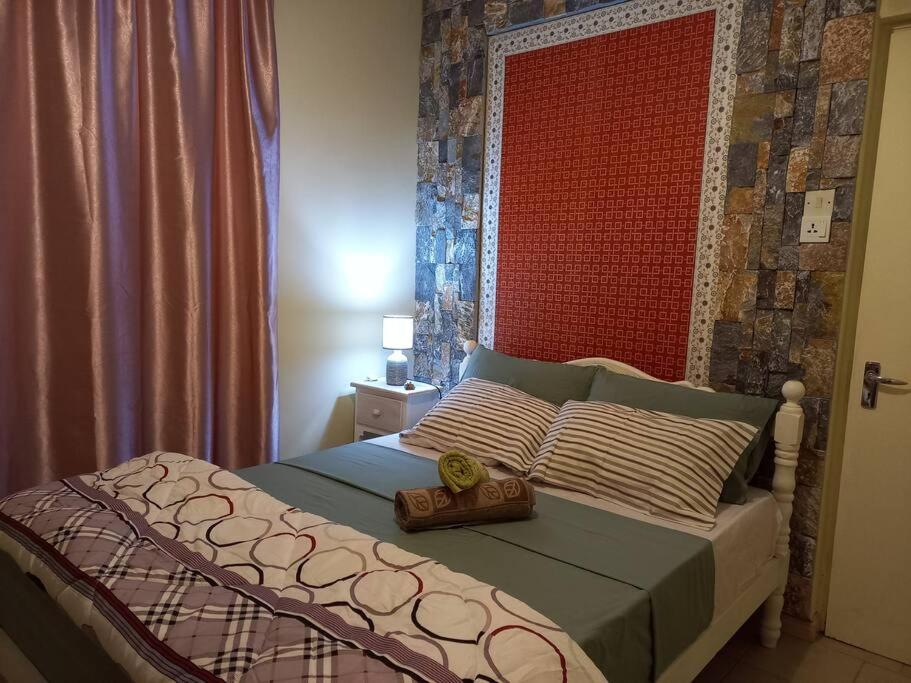 a bedroom with a bed with a red head board at Vacances Le Nereide Blue Bay in Blue Bay