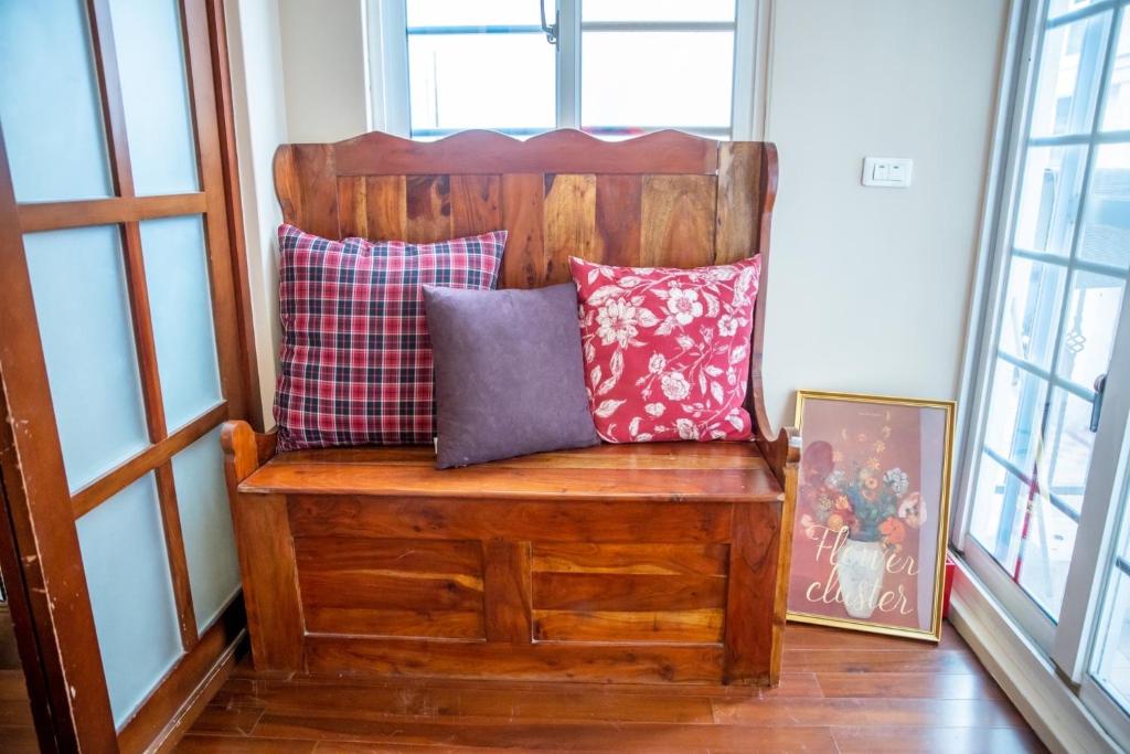 a bench with pillows on it in a room with windows at 城市阿瑪菲-花蓮火車站前 in Hualien City