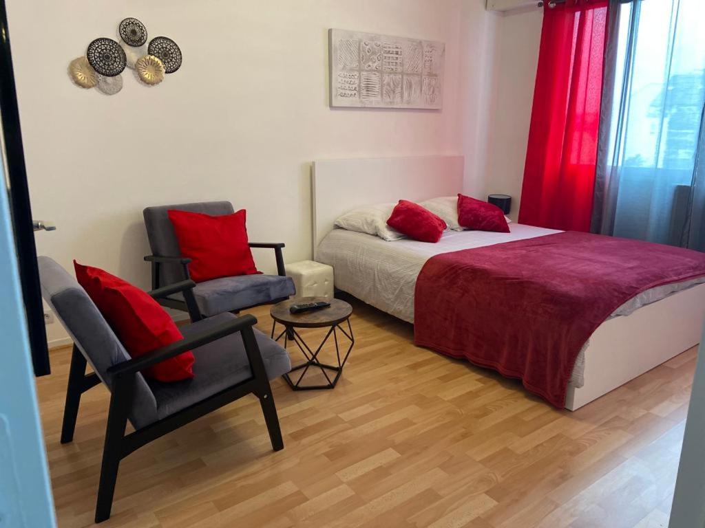 Un dormitorio con una cama con almohadas rojas y una silla en APPART PORT DU CANAL, en Dijon