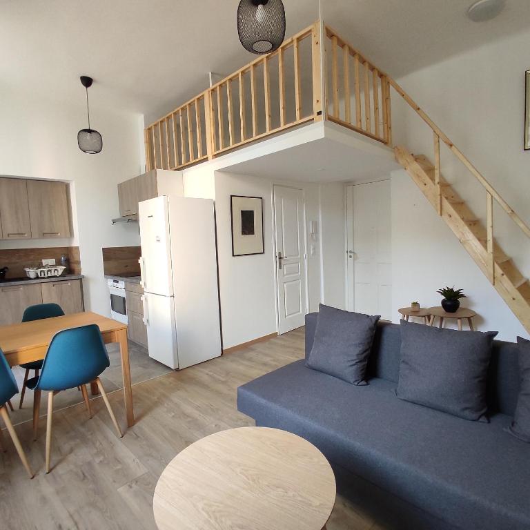 un salon avec un canapé bleu et une cuisine dans l'établissement 2 à 6 personnes - WELCOME TO NICE ! LOGEMENT PORT, à Nice