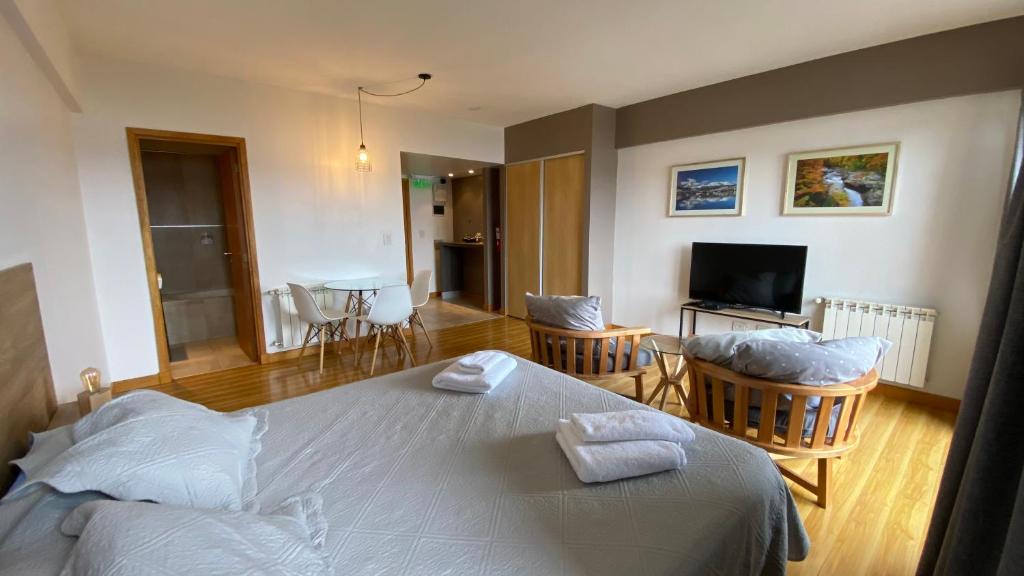 a bedroom with a bed and a living room at Polo Sur Apartamentos in Ushuaia