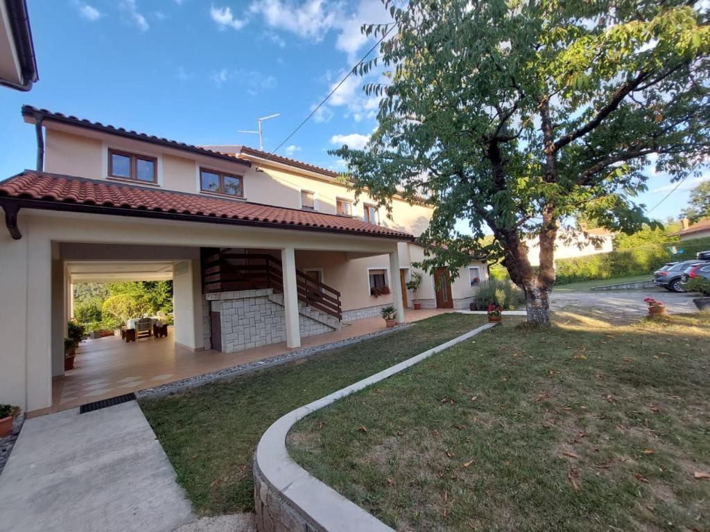 a house with a patio and a yard at Sobe Ivančica in Rupa