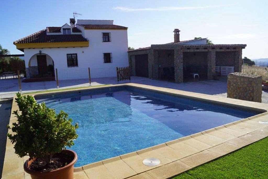 una gran piscina frente a una casa en Casa Rural Recreo en El Gastor