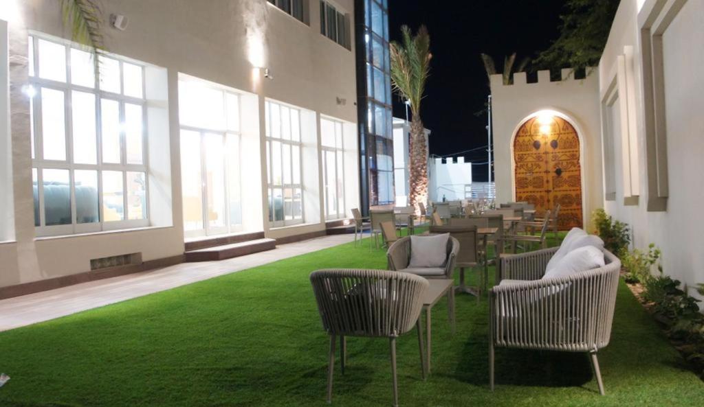 une chambre avec des chaises et des tables dans un bâtiment dans l'établissement Hotel Delphin-Nouadhibou, à Nouadhibou