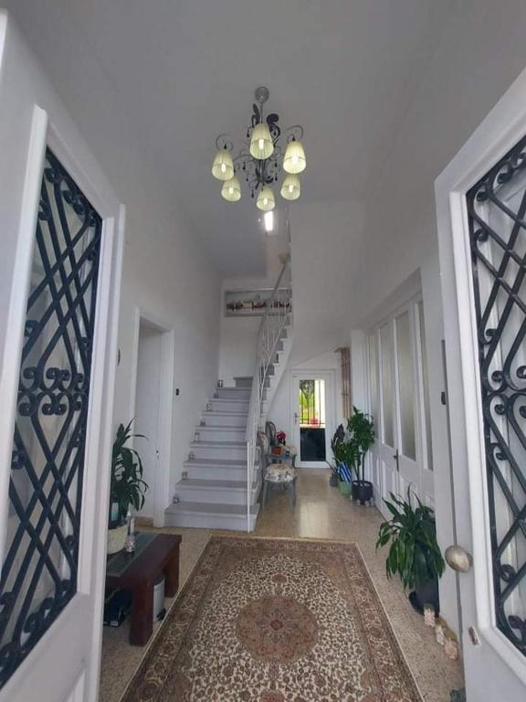 korytarz ze schodami i żyrandolem w obiekcie Tower Traditional Pool Villa w mieście Kremasti