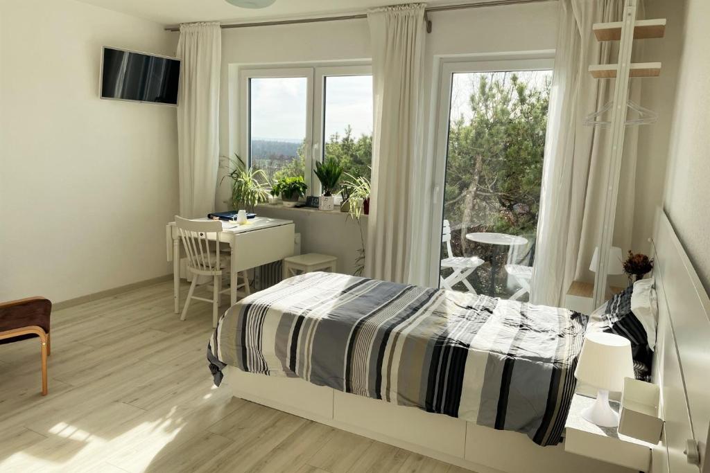een slaapkamer met een bed, een bureau en een raam bij Apartment Sonnenhaus in Freudental
