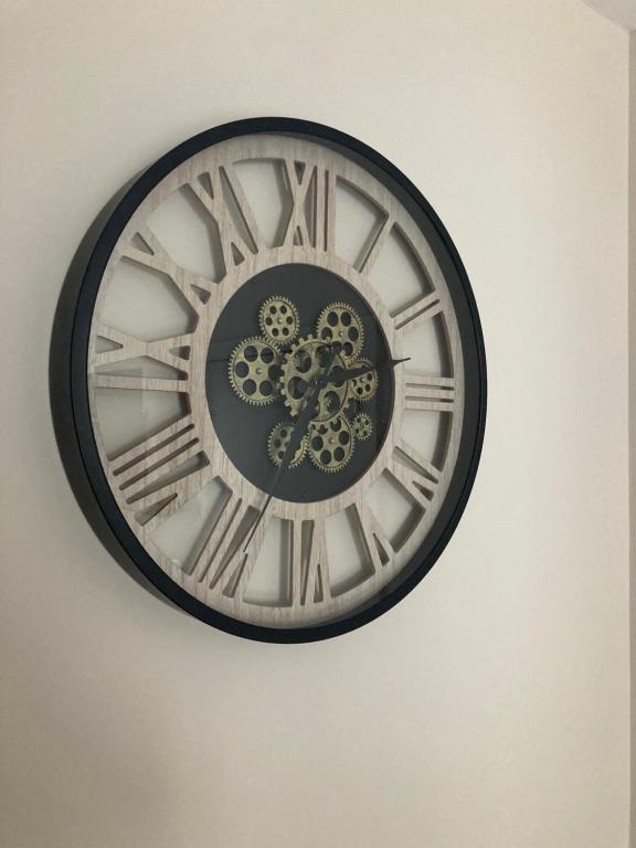 a black and white clock on a wall at Côté Grange in Tournai