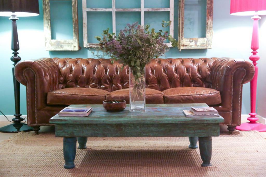 un sofá de cuero marrón sentado en una sala de estar con una mesa en Violeta Boutique en Barcelona